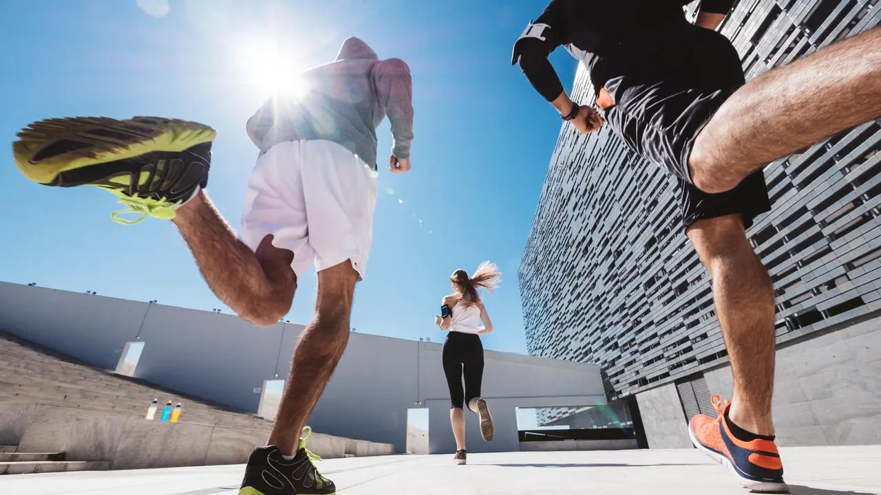 three friends athletes jogging in a modern building district